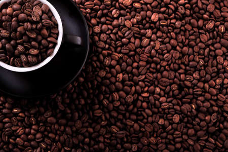 Black coffee cup with roasted beans background