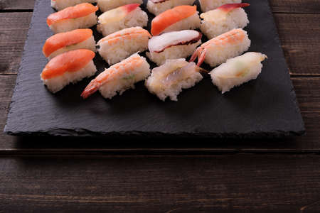 Sushi japanese food black slate platter wood tableの写真素材