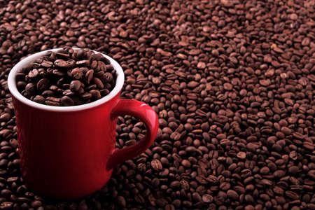 Red coffee mug filled with beans backgroundの写真素材