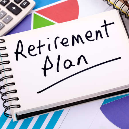 The words Retirement Plan written on a bar graph surrounded by pencils, books and calculator.  の写真素材