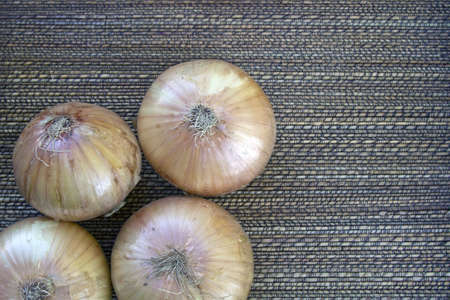 Unpeeled Onions with Basket Weave Textured Backgroundの写真素材