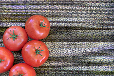 Red Ripe Tomatoes on basket weave backgroundの写真素材