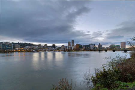 Portland Oregon downtown city skyline and Hawthorne Bridge over Willamette River waterfront during eveningの写真素材