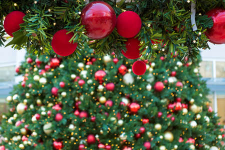 Christmas holiday tree garland decorated with red round ornaments and Christmas tree background