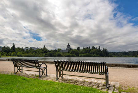 Park bench along scenic Capitol Lake in Olympia Washington State on a cloudy dayの写真素材