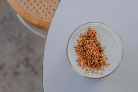 Top view of flat lay shot of a glass of whipped cream milk with crushed wafer topping that sprinkled over the surface, blurred background or narrow depth-of-fieldの写真素材