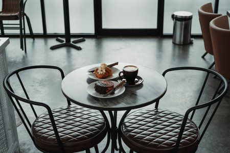 Coffee Table Contains Breakfast Menu Set: Almond Croissant, Chocolate Crombolomi, and Coffee on a Cafeの写真素材
