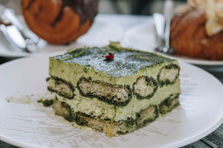 Close-up and details shot of Layered Japanese Matcha Cake on a white plate with blurred backgroundの写真素材