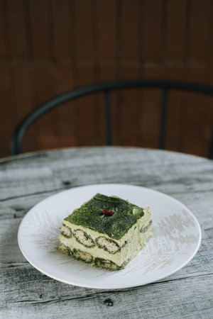 Portrait or vertical shot of a plate of Japanese Green Tea or Matcha Cake with bokeh backgroundの写真素材