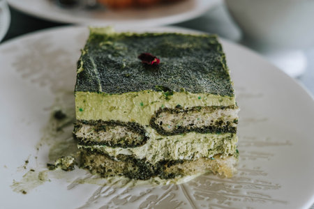 Close-up and details shot of Layered Japanese Matcha Cake on a white plate with blurred backgroundの写真素材