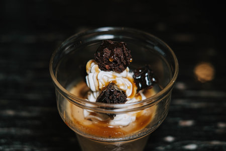 Close-up shot of a glass of ice cream with coffee and additional brownies cake. Blurred background.の写真素材