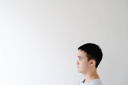 A young Asian man's head is looking at the left side in isolated white backgroundの写真素材