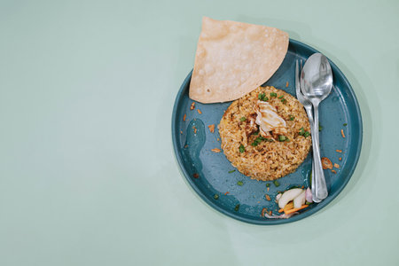 Flat lay or top view shot of a plate of Nasi Goreng or Fried Rice with cracker, carrots, and...