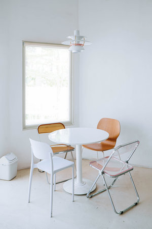 Portrait or vertical shot of minimalist and warm cafe interior contains plastic dining chair, a...