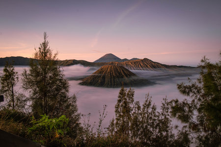 Sunrise at Gunung Bromo or Bromo Mountain which is covered by clouds and Semeru Mountain as the...