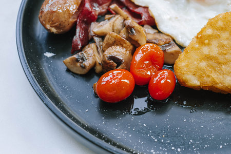 Selective focus shot of cherry tomatoes on a black or dark plateの写真素材