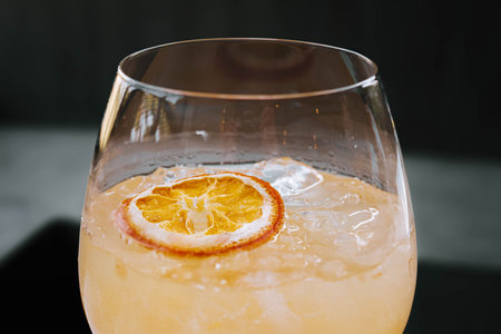 Close-up and selective shot of an Ice Tropical Sangria or Orange Cocktail with Soda on the wine glassの写真素材
