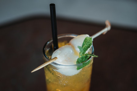 Two lychee fruit with mint leaves in a glass of lemon juice. Unfocused or blurred background. Top view angle.の写真素材