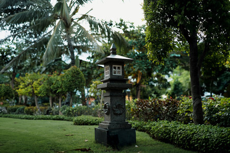 A traditional Balinese stone lantern in the park with bokeh backgroundの写真素材