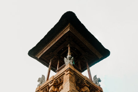 Balinese Hindu temple with black straw rooftop against white sky made of bricksの写真素材