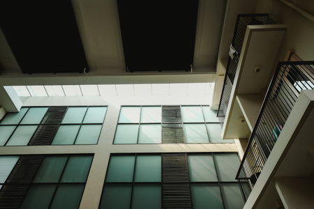 Tall building with glass facade that has dark windows and metal frameの写真素材