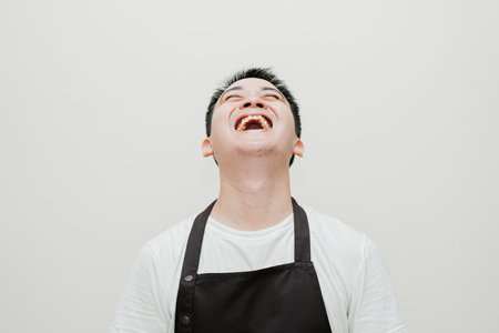 Headshot photo of Asian chef with laugh face on isolated background