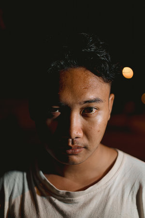 Young Southeast Asian man looking at the camera. Portrait or vertical photo.