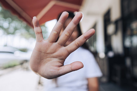 Close up of a open palm hand creating gesture of privacy, refusal, stop or need personal space with bokeh backgroundの写真素材