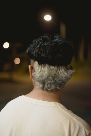 Two toned hairstyle colors on young Southeast Asian man. Close up shot with bokeh background.の写真素材