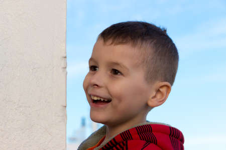 A little boy laughing next to a white wall. Captured at Port Melbourneの写真素材