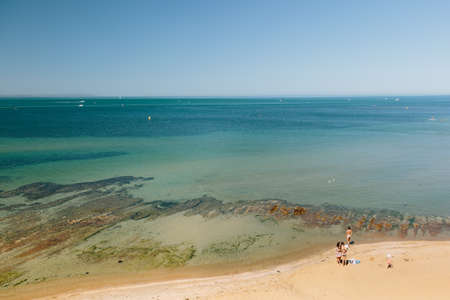 MELBOURNE/AUSTRALIA - FEBRUARY 6: Some people enjoying the perfect Melbourne weather at Ricketts Point where there are some beautiful rock formations on the shoreline.のeditorial素材