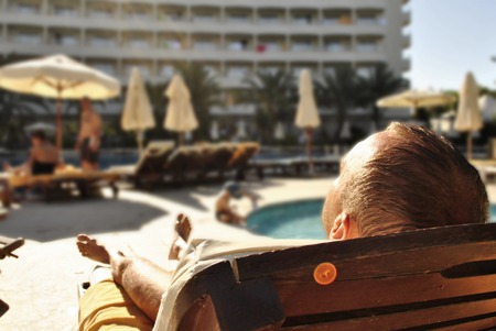 A man is sunning on a sun lounger at a hotel on vacation in Turkeyの写真素材
