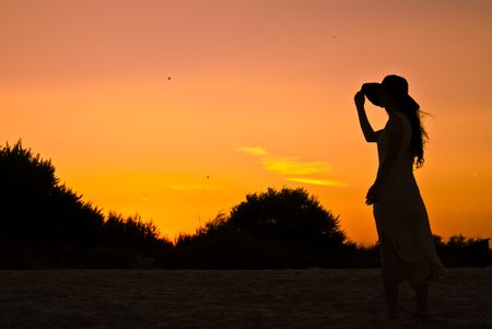 A lonely girl on the beach at sunsetの写真素材