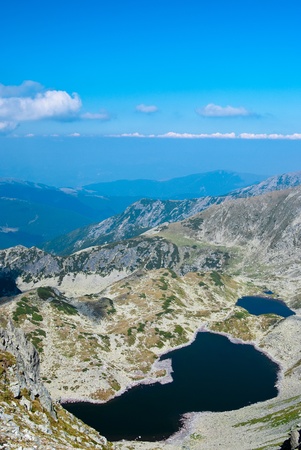 Landscape of a glacial lake in National Park Retezat, Romania, with mountains in backgroundの写真素材