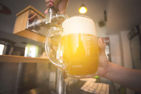 Barman pouring beer into glass in restaurant, pub, barの写真素材