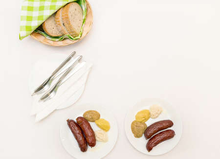 Sausages, mustard, horseradish and bread on the white table clothの写真素材