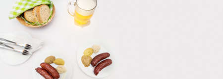 Sausages, mustard, horseradish, bread and beer on the white table clothの写真素材
