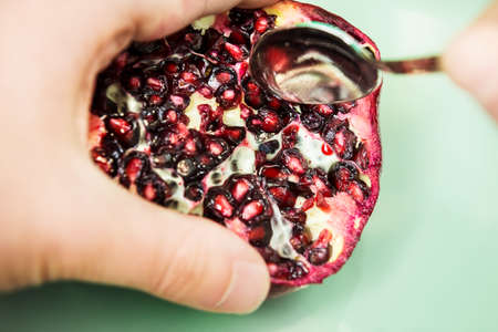 Eating pomegranate by spoonの写真素材