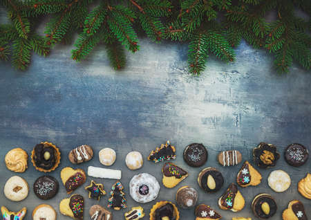 Christmas sweets with coniferous branches on the wooden background with free spaceの写真素材