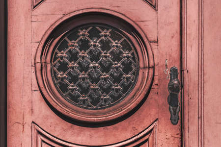 Old wooden pink door with round window