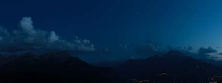 nocturnal alpine landscape with mountains and clouds