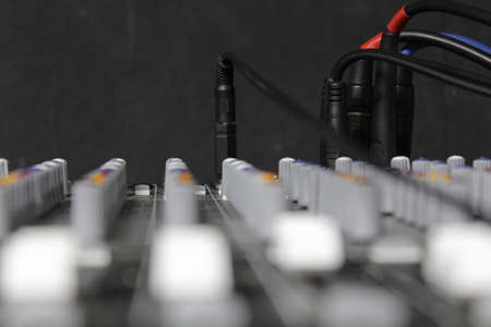 macro view of plugged cables and controllers on a sound mixer