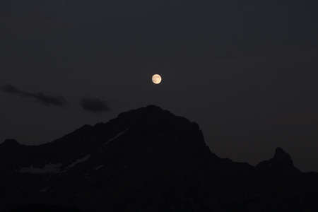 moon over a mountain peak