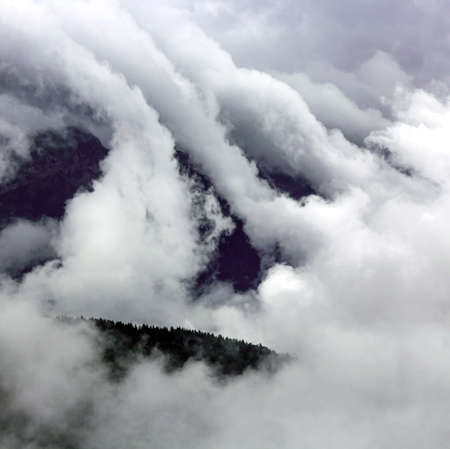 view of a mountain covered by clouds