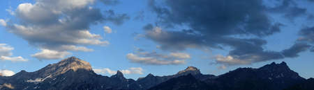 panoramic view of a mountain range and clouds in the evening