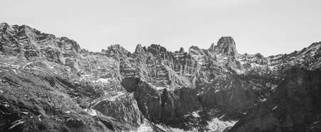 a mountain wall with patches of snow
