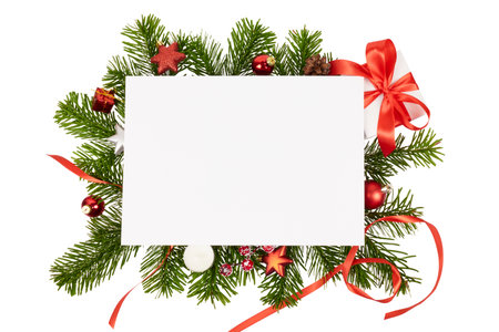 christmas frame with fir branches and decorations and blank white gift card isolated on whiteの写真素材