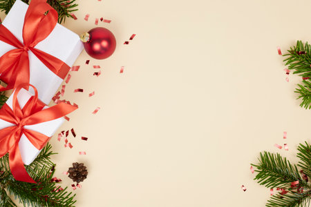 beige christmas card background with gift boxes, fir tree branch and red balls, copy spaceの写真素材