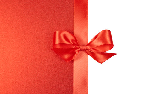 red ribbon on red christmas glitter paper background isolated on whiteの写真素材