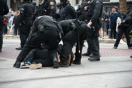 PORTLAND, OREGON JANUARY 25 2017, Police officers in riot gear, arresting a person who was blocking the road, protesting of the police reaction to inauguration day protests.のeditorial素材